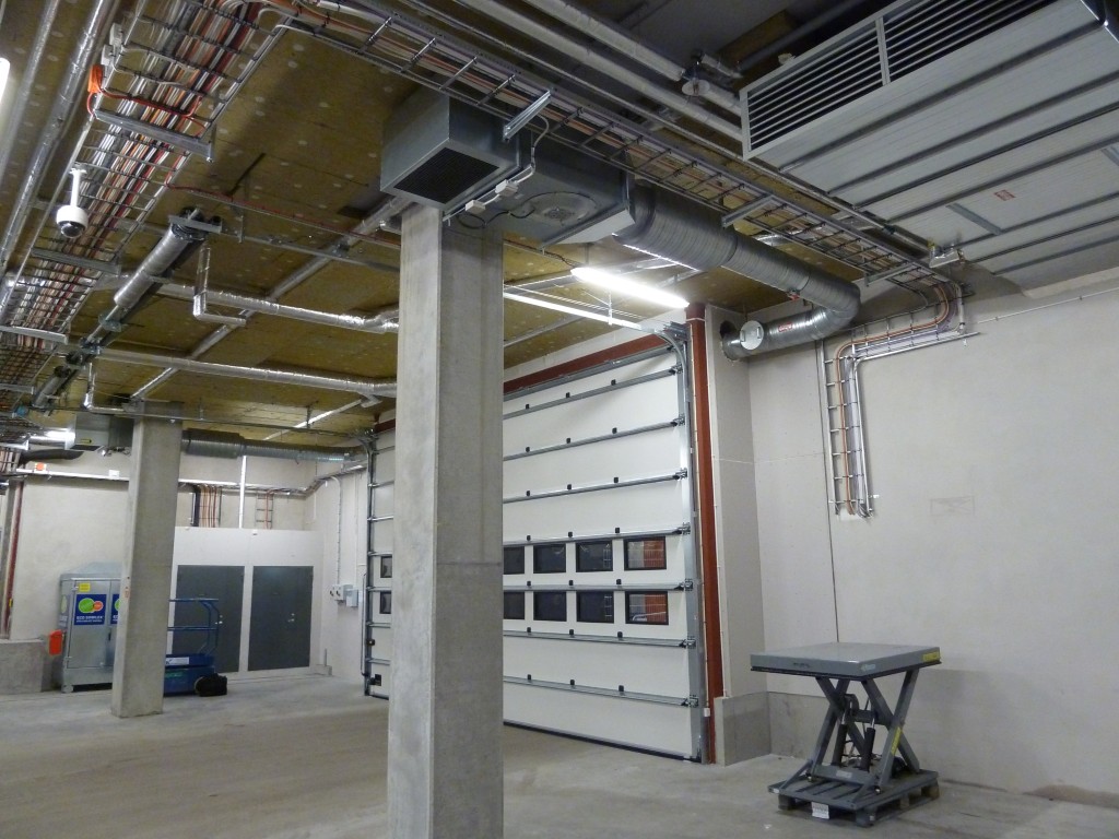 Luftridåaggregat med kanal till ridåtrumma på utsidan Ett luftridåaggregat installerat vid stor port