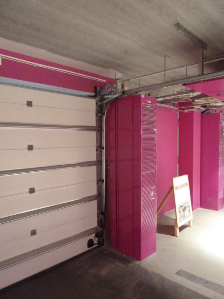 En sidoblåsande luftridå vid garageport lackerad i rosa färg
